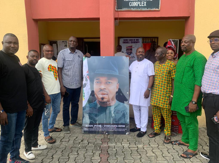 3rd R - Hon. (Pharm) Victor Ofobrukueta receiving portrait picture from the LG PDP Chairman, 2nd L - Hon. Felix Erhimedafe at council secretarial while others look on